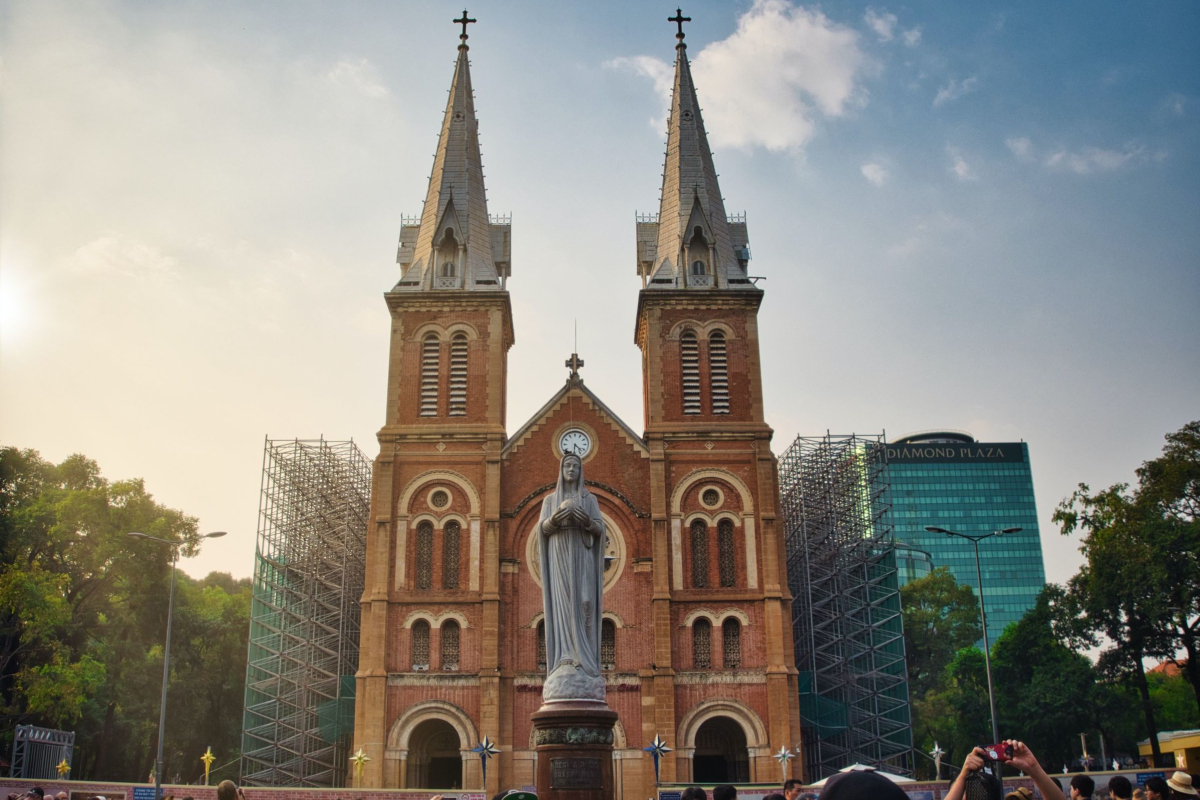 A front view of Notre Dame Cathedral in Ho chi Minh city with the Statue of the Virgin Mary in the gardens