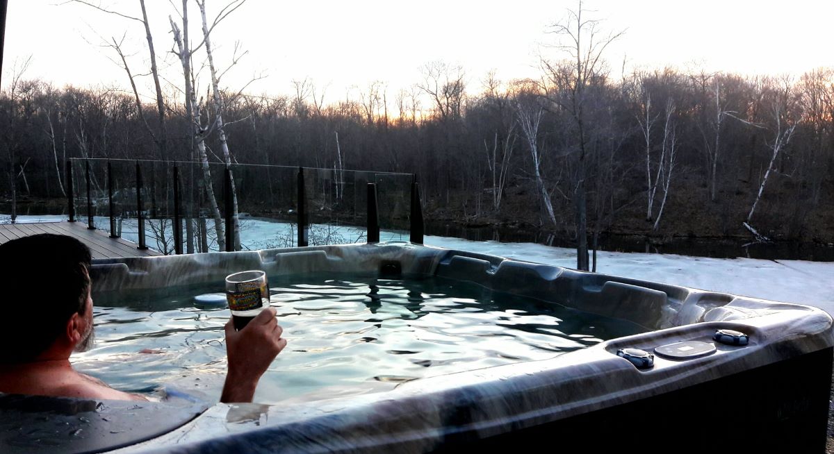 Man in hot Tub admiring the view with a beer